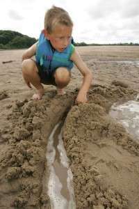 Boy_playing_in_sand_on_beach