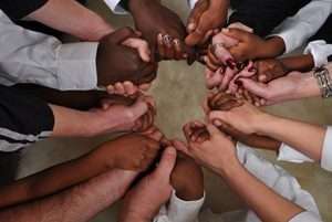 Black and white hands forming a circle.